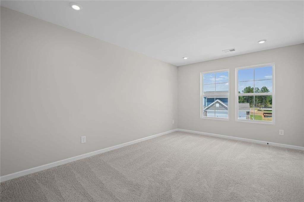Recessed lighting, light gray wall paint, and gray carpeting