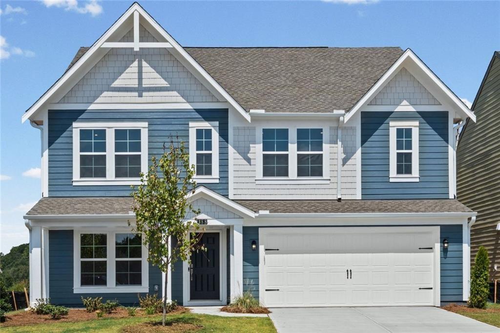 Two-story residence featuring blue horizontal siding and white shake accents