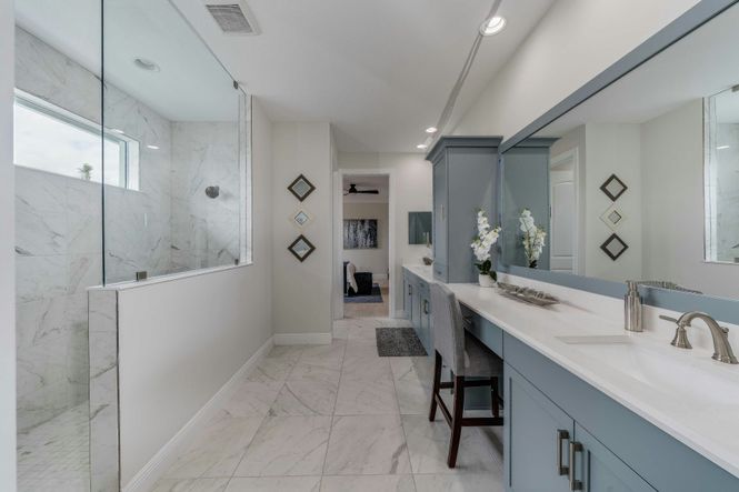 Master bath split vanity with view of walk-in shower and large tile flooring