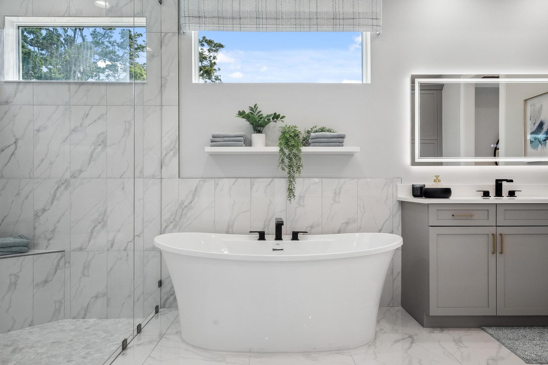 Master bath with modern soaker tube, vertical installed tile on wall and in shower