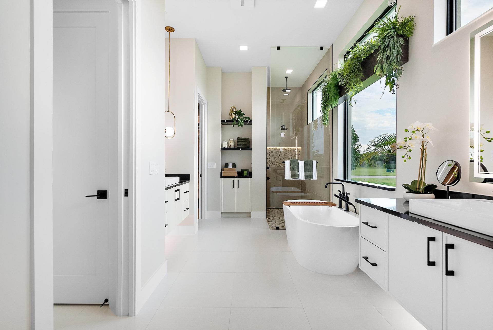 Master bath with oval tub and walk-in shower, floating cabinet in black and white