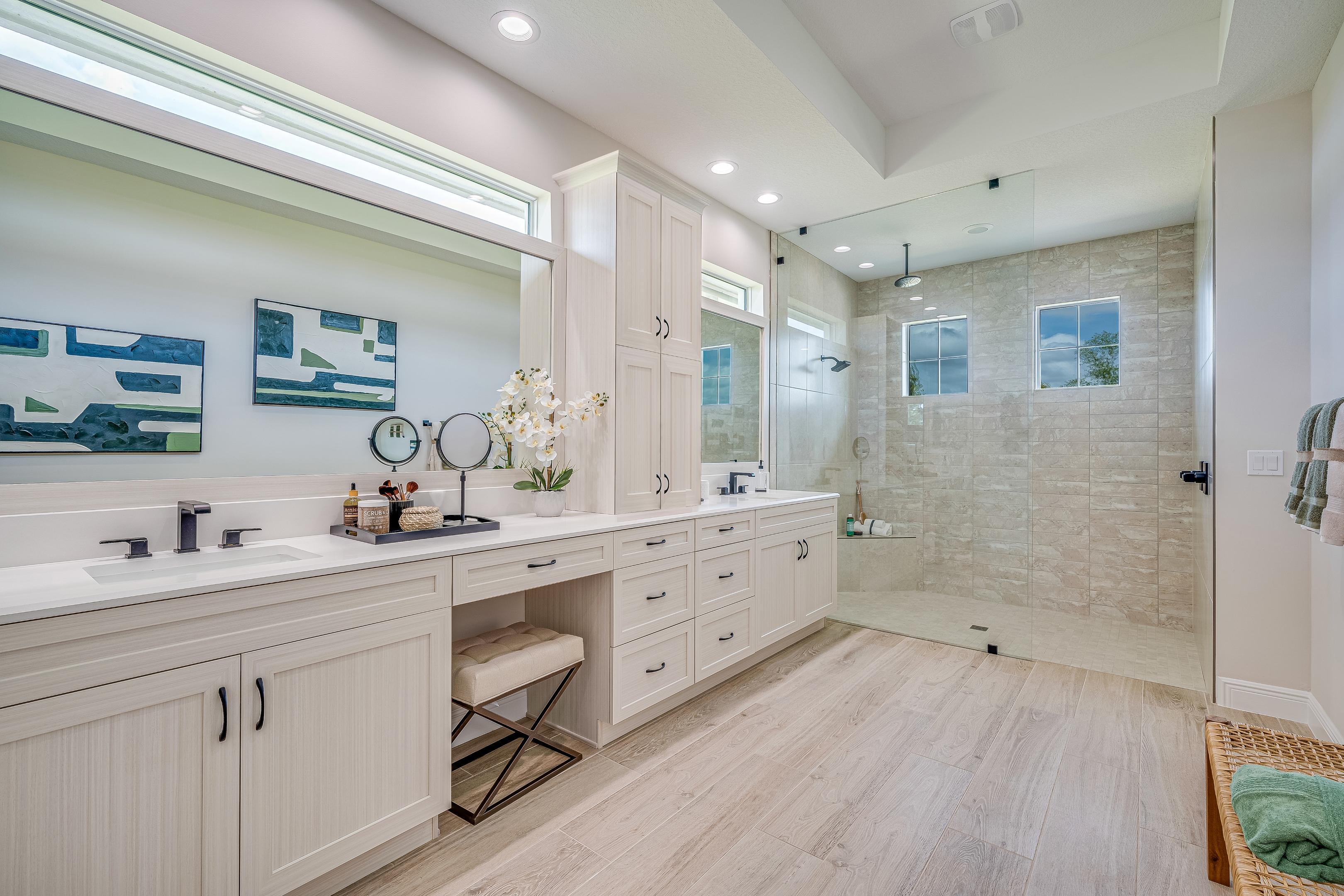 Master bath with wood tile flooring, walk-in shower and dual vanity with tower