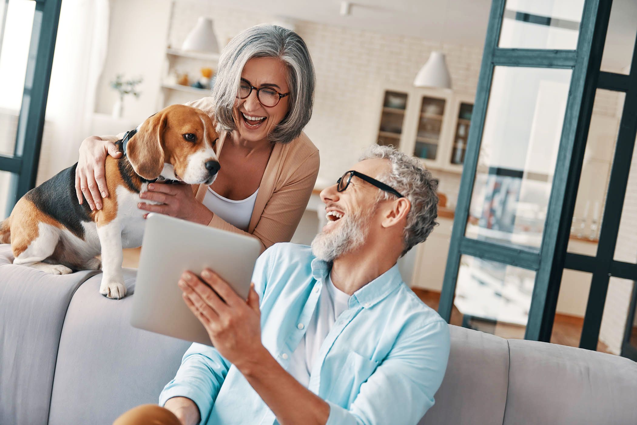 Active Adult Couple playing with a Dog in the Living Room
