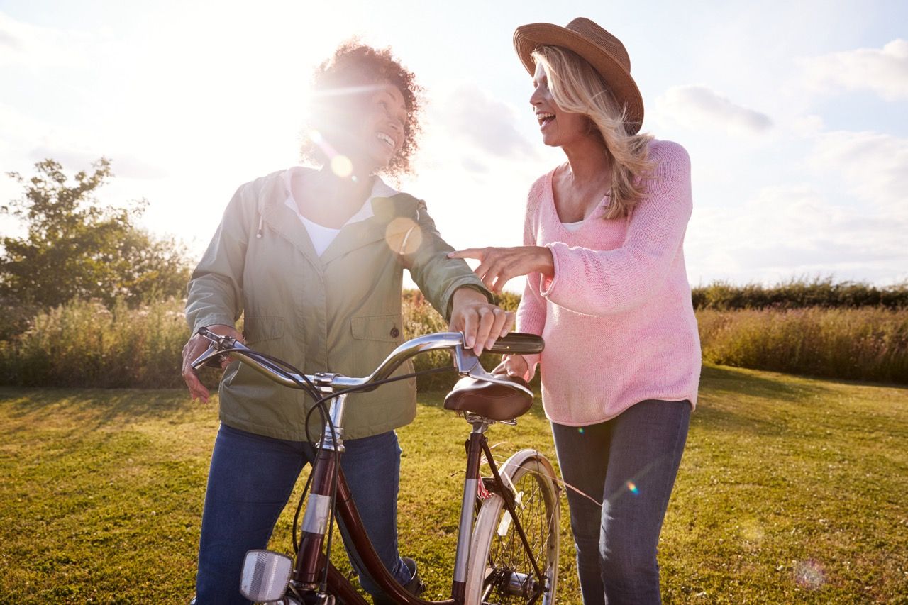 Two Women Standing next to a Bike Outside