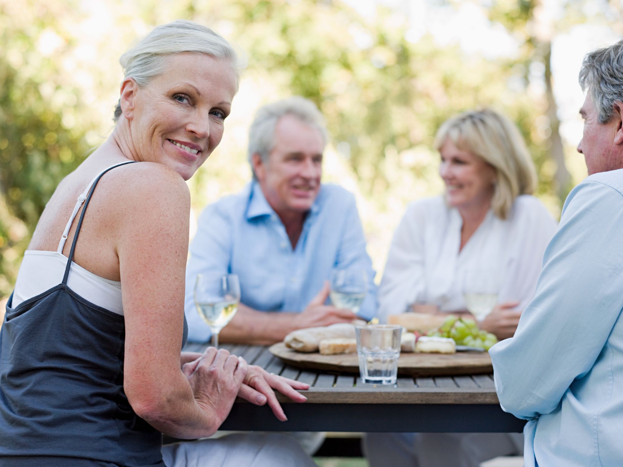 Group of People enjoying wine, fruit and bread outdoors