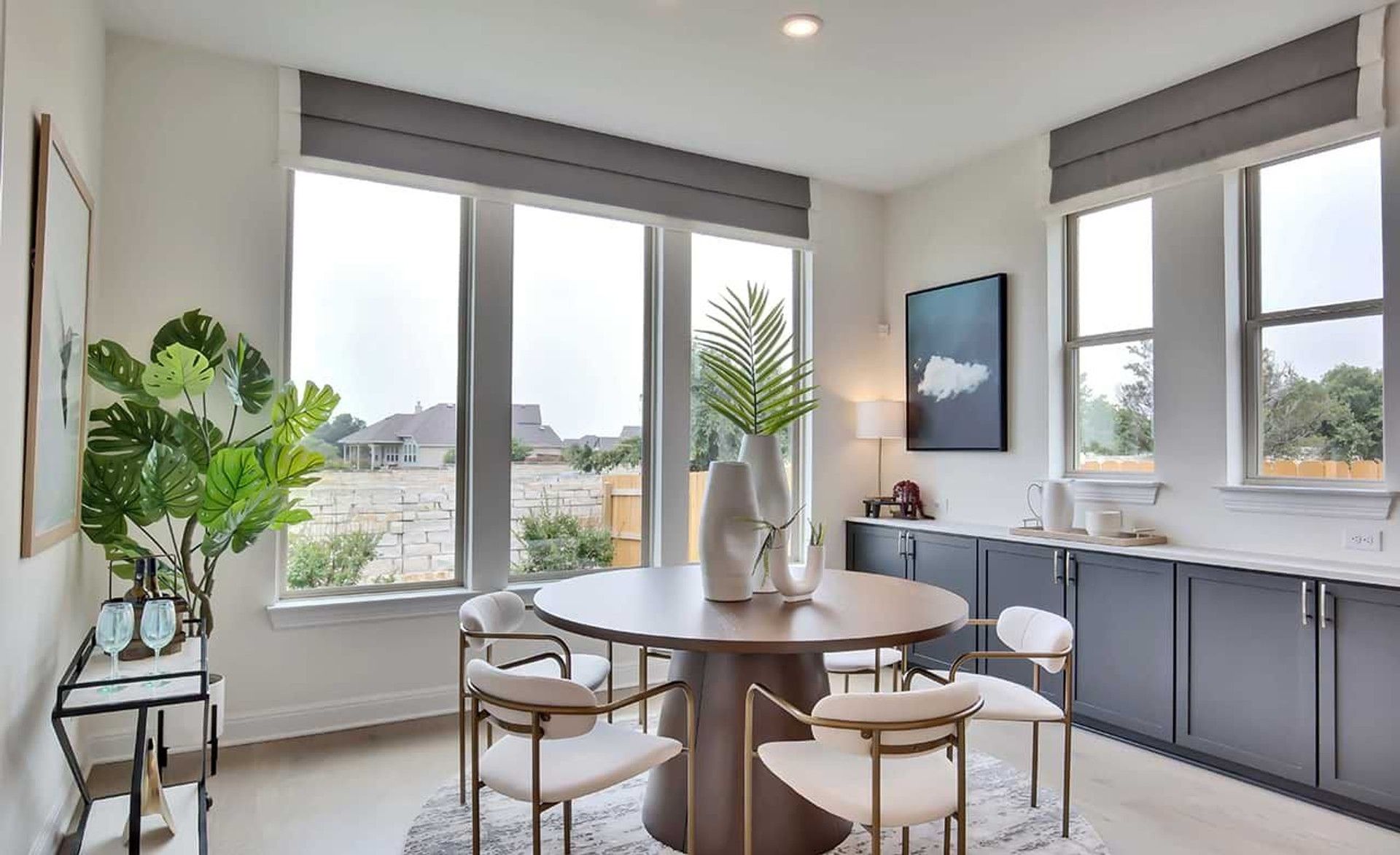 Expansive windows flood the chic dining area with light, emphasizing refined finishes. Georgetown, TX.