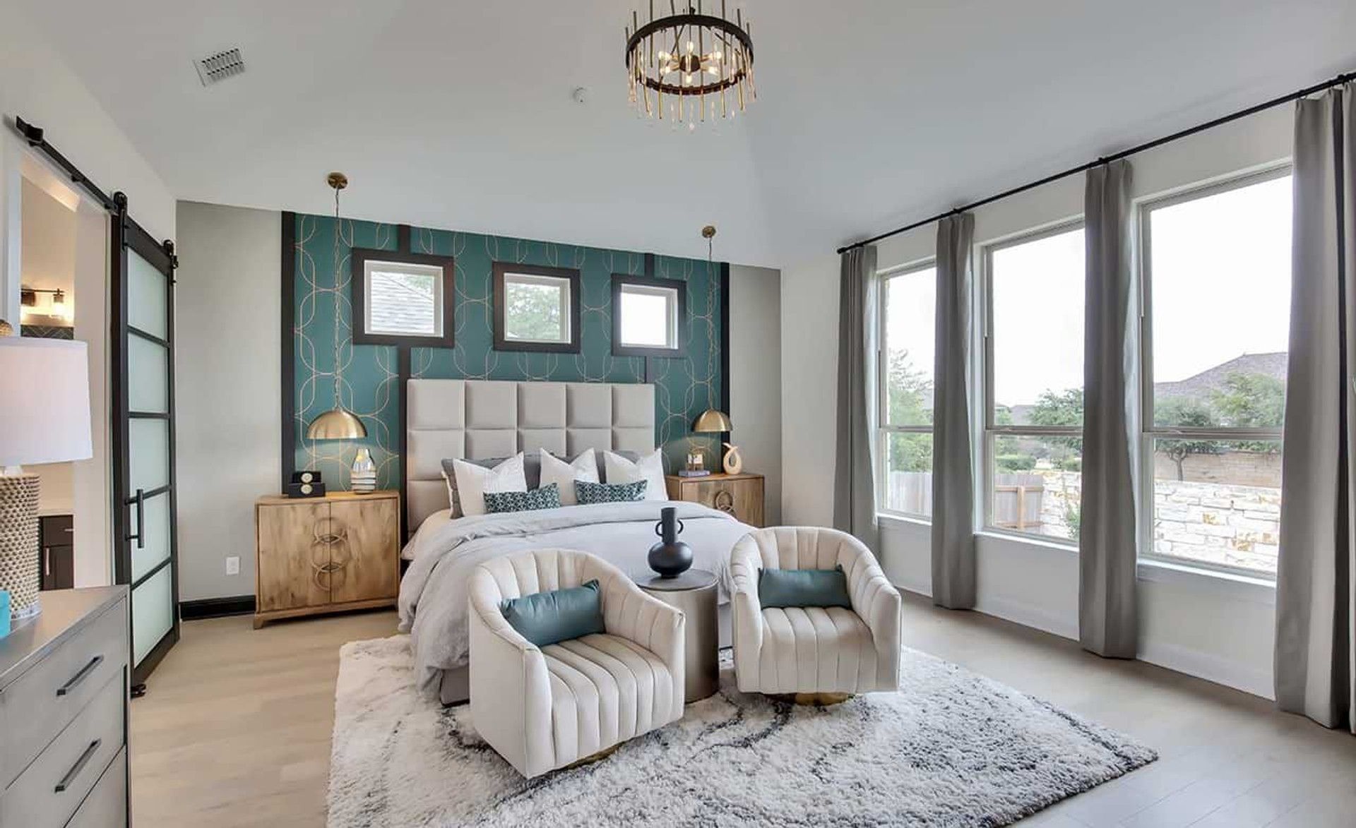 High ceilings, expansive windows, and designer fixtures elevate this Oaks at San Gabriel bedroom.