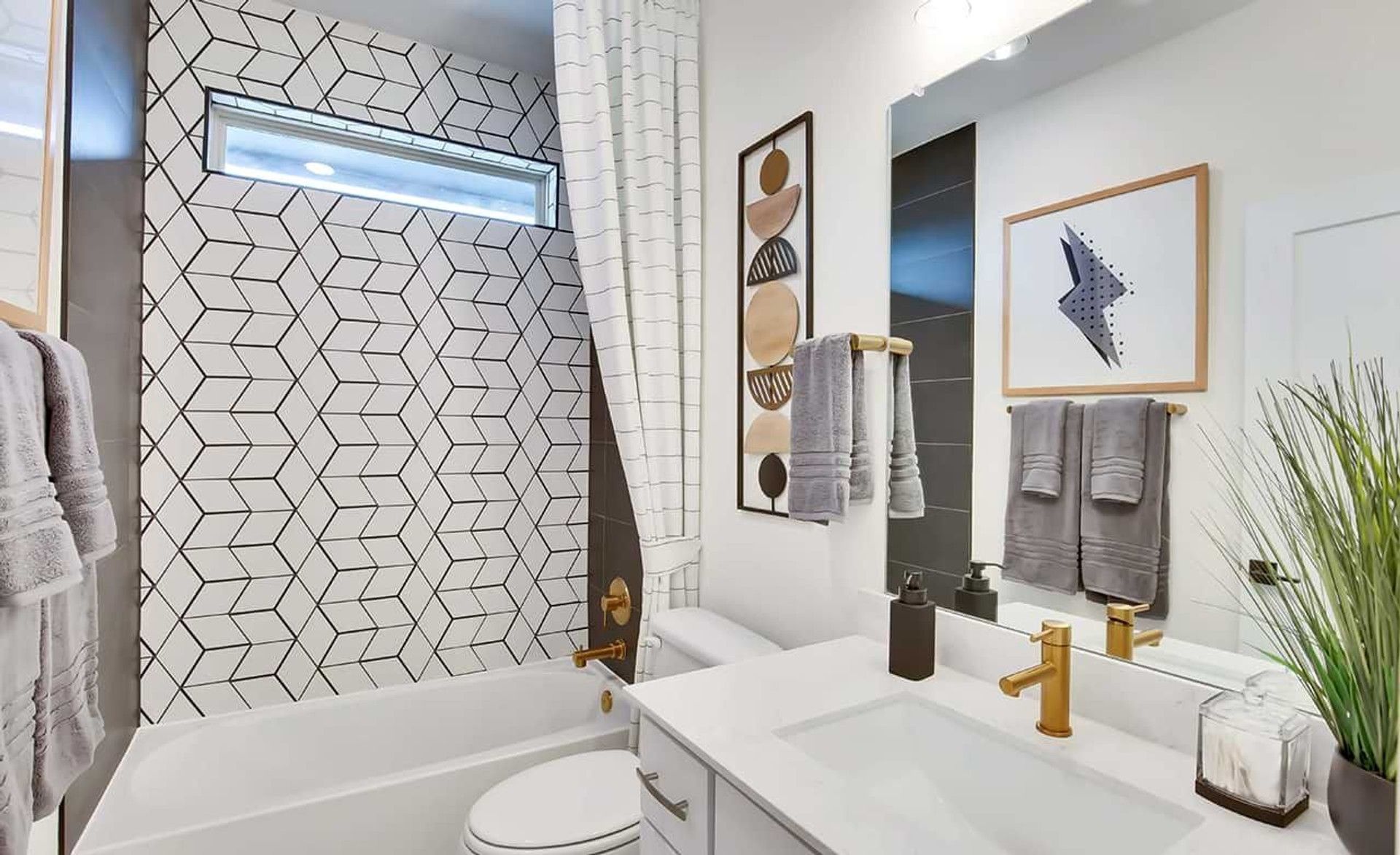 Discover sleek gold fixtures and geometric tiling in this luxurious Oaks at San Gabriel bathroom.