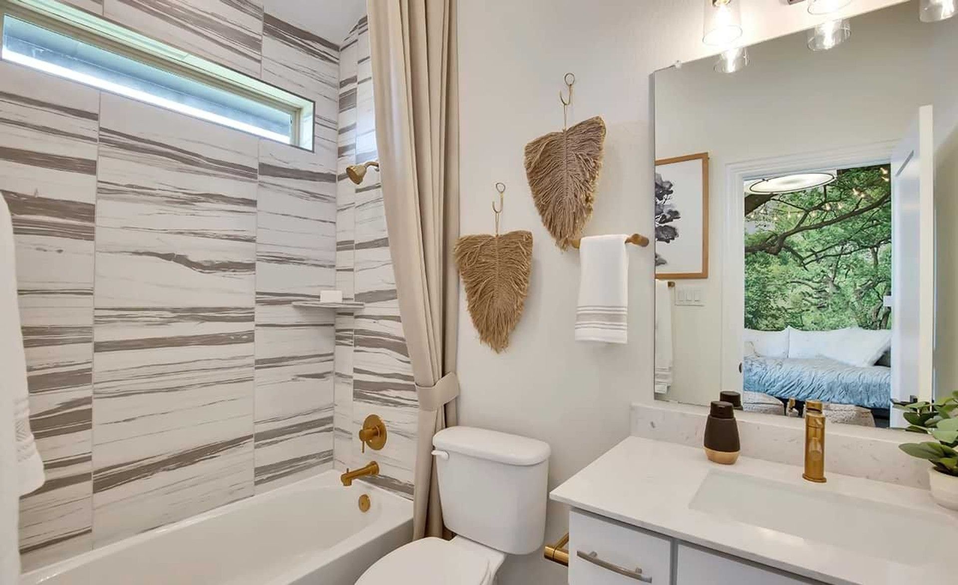 Marvel at the opulent gold fixtures and chic marble tilework in this Oaks at San Gabriel bathroom sanctuary.