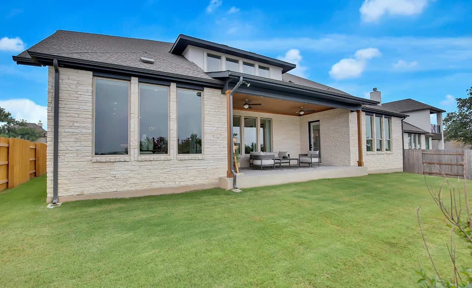 Expansive patio and sleek stone façade gracing the Oaks at San Gabriel, Texas. Luxurious outdoor living.