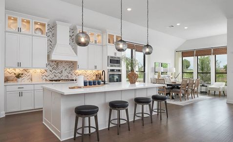 Sleek white cabinetry and chic pendant lighting define this Anthem home's stylish kitchen.