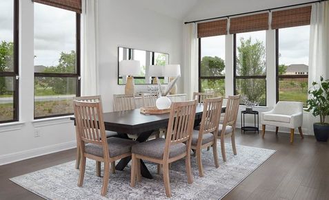Oversized windows and luxurious wood finishes exude elegance in this Anthem community dining room.