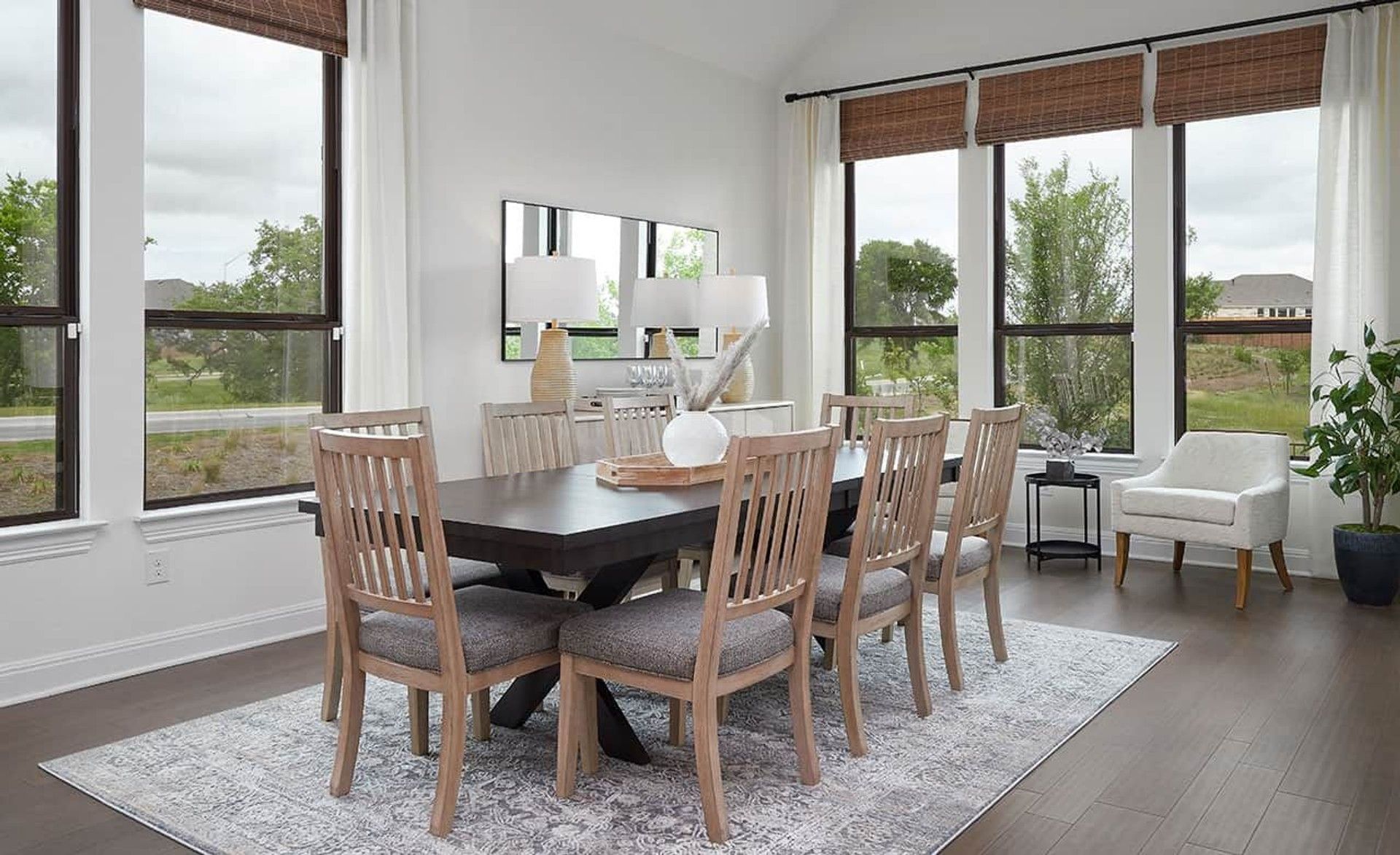 Oversized windows and luxurious wood finishes exude elegance in this Anthem community dining room.
