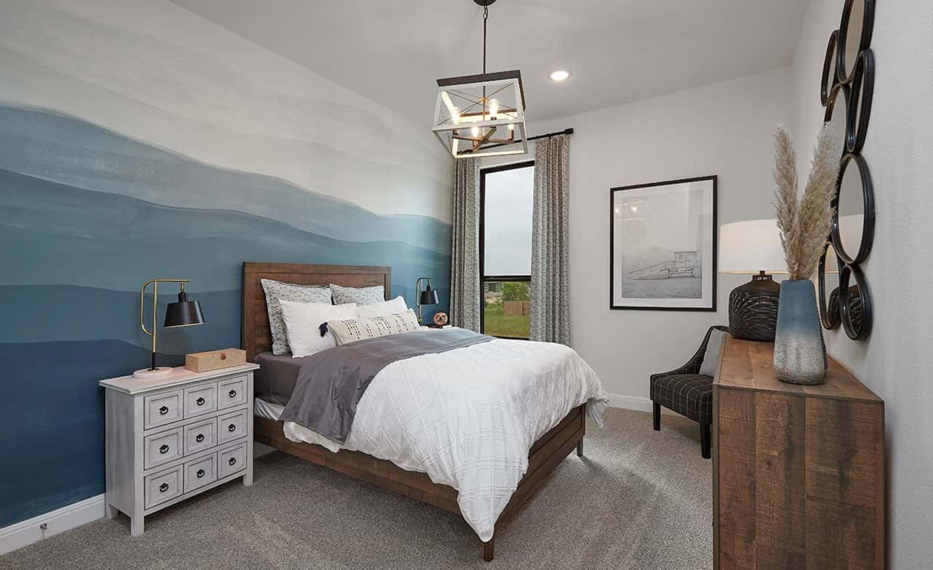 Luxurious Anthem bedroom boasts a stunning blue accent wall and chic pendant lighting.