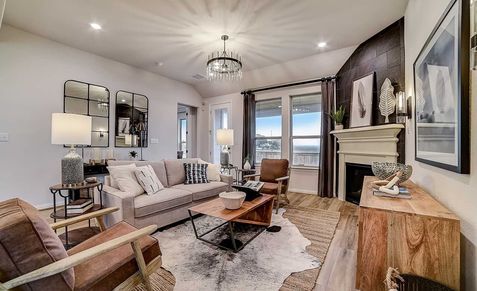 Discover Dauer Ranch's elegance with a grand chandelier, sleek fireplace, and exquisite woodwork.