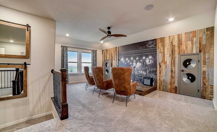 Experience upscale living in Dauer Ranch with this elegant home theater featuring leather seating and a concert mural.