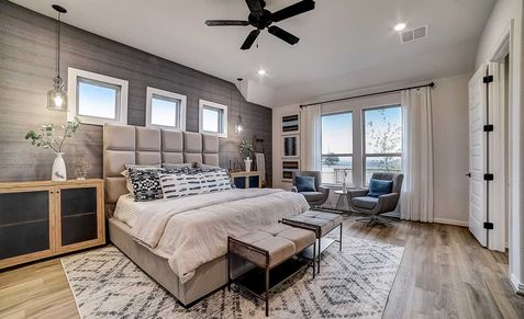 Dauer Ranch bedroom boasts plush textures, expansive windows, and rich wood flooring for ultimate luxury.