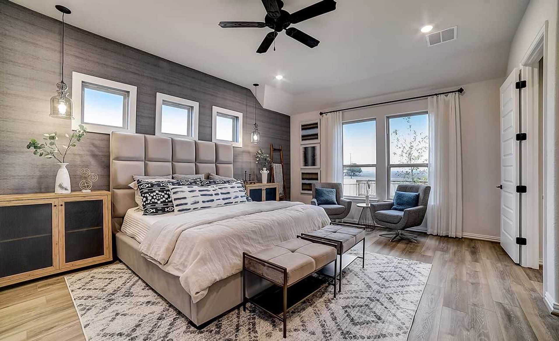 Dauer Ranch bedroom boasts plush textures, expansive windows, and rich wood flooring for ultimate luxury.