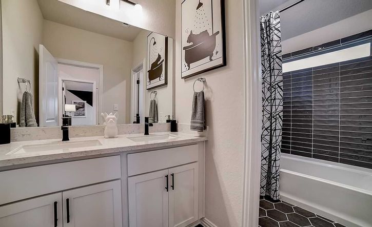 Elegant dual sinks, premium marble surfaces, and chic hexagonal tiles enhance this Dauer Ranch bathroom.