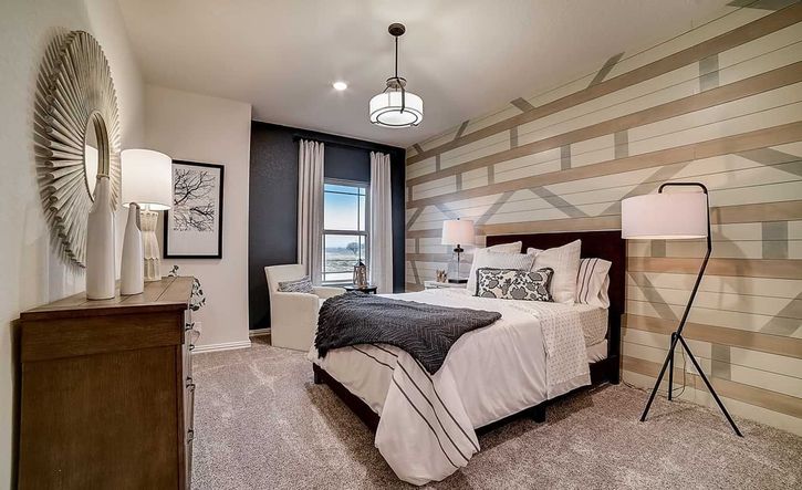 Luxurious bedroom with geometric accent wall and plush carpeting in Dauer Ranch.