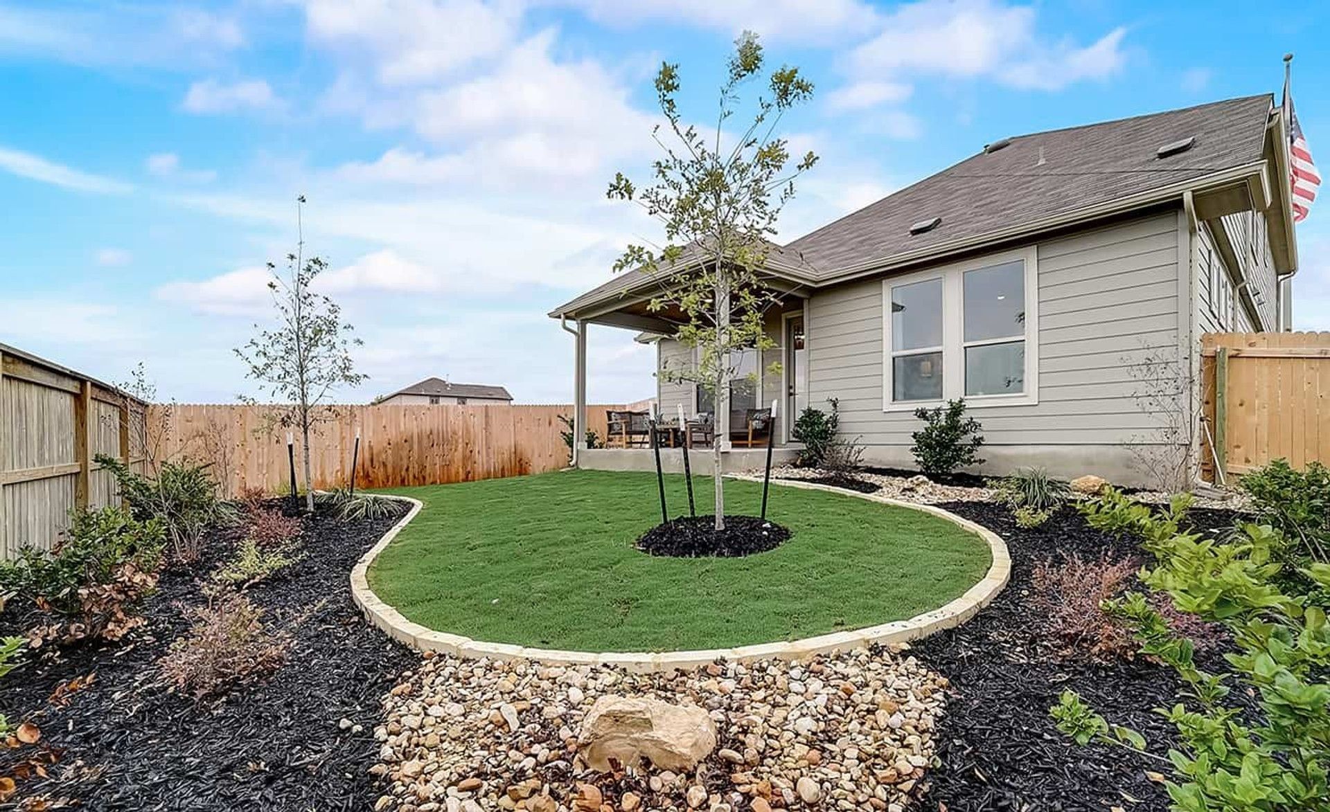 Immaculate landscaping surrounds this modern ranch house's elegant porch at Dauer Ranch, Texas.