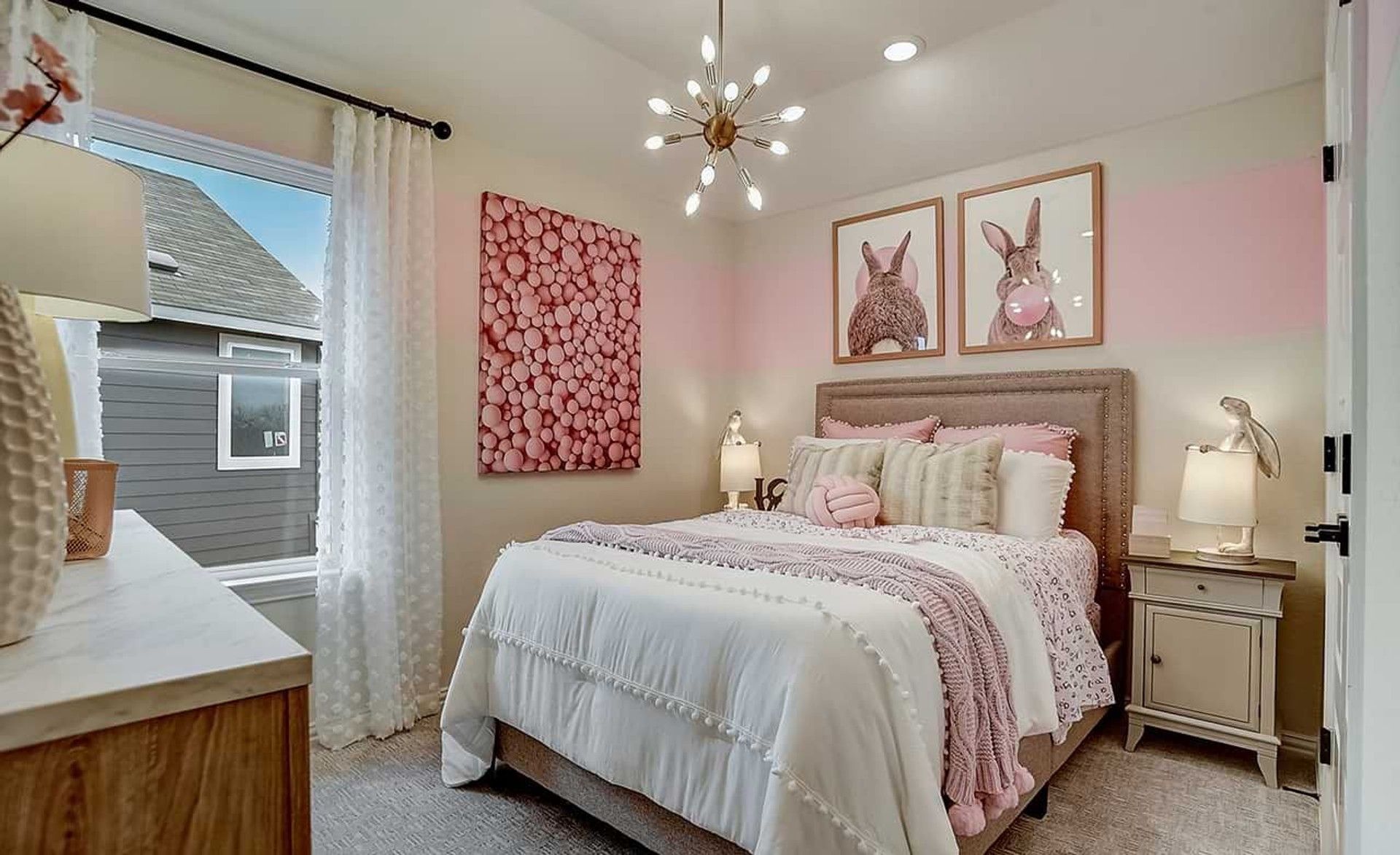 Elegant bedroom features chic modern chandelier and soft pink accents, embodying luxury at Casinas at Gruene.