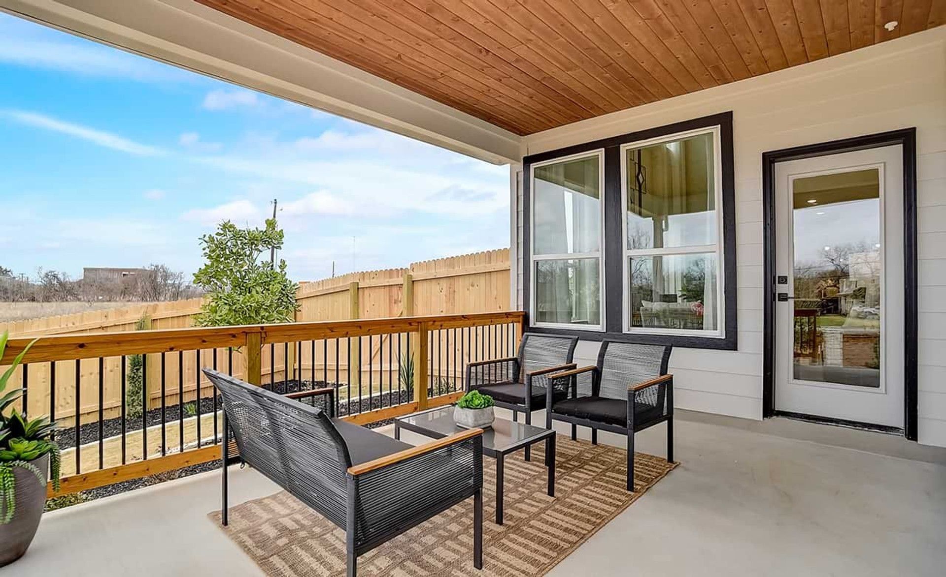 Enjoy serene views from this upscale patio, featuring a wood ceiling and sleek seating in Gruene, Texas.