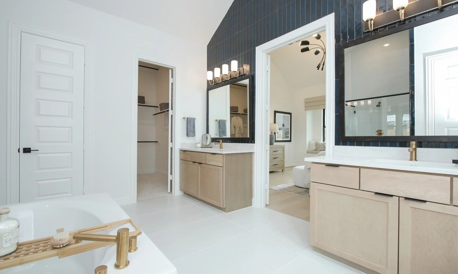 Chic dual vanities, gold fixtures highlight elegance in Coastal Point's upscale design.