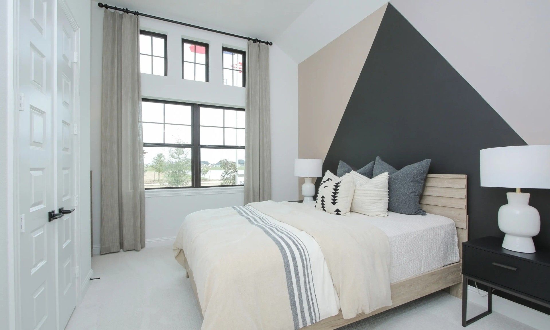 Geometric accent wall in this Coastal Point bedroom showcases modern design and sleek aesthetics.