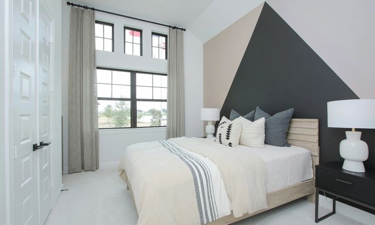 Geometric accent wall in this Coastal Point bedroom showcases modern design and sleek aesthetics.