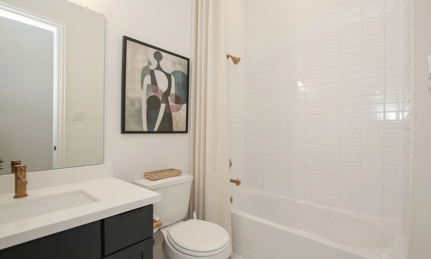 Sophisticated white tiling and brass fixtures in a luxurious Coastal Point bathroom reflect modern elegance.