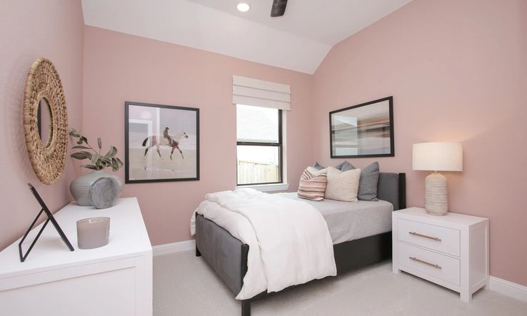 Luxurious bedroom featuring soft pink walls and tasteful decor, set in the esteemed Coastal Point community.