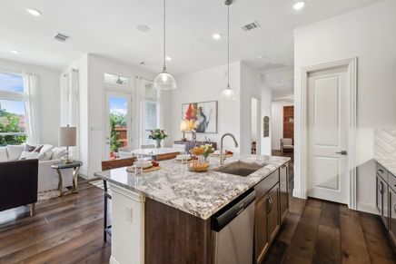 Elegant granite island and rich wood flooring highlight this Heritage Park kitchen's tasteful design.