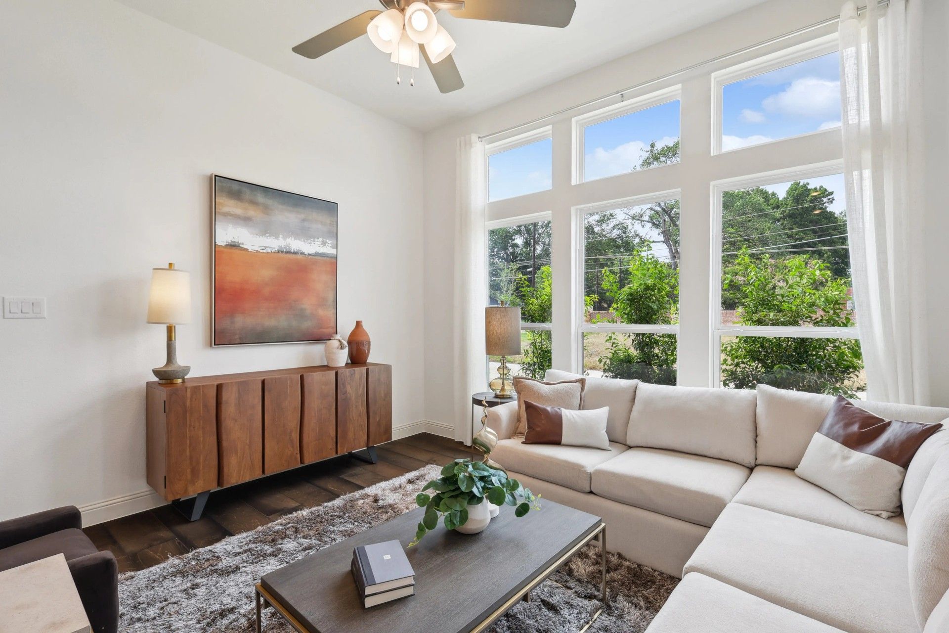 The spacious living room features expansive windows and a plush sectional, epitomizing elegance in Heritage Park.