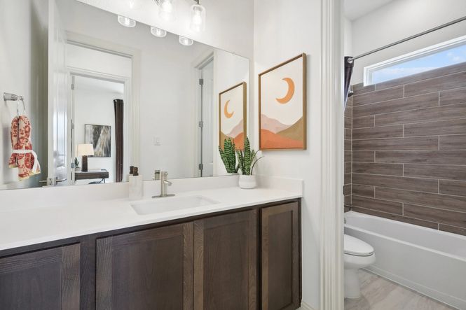 Luxurious dark wood cabinetry and exquisite wood-tiled shower enhance this Heritage Park bathroom.