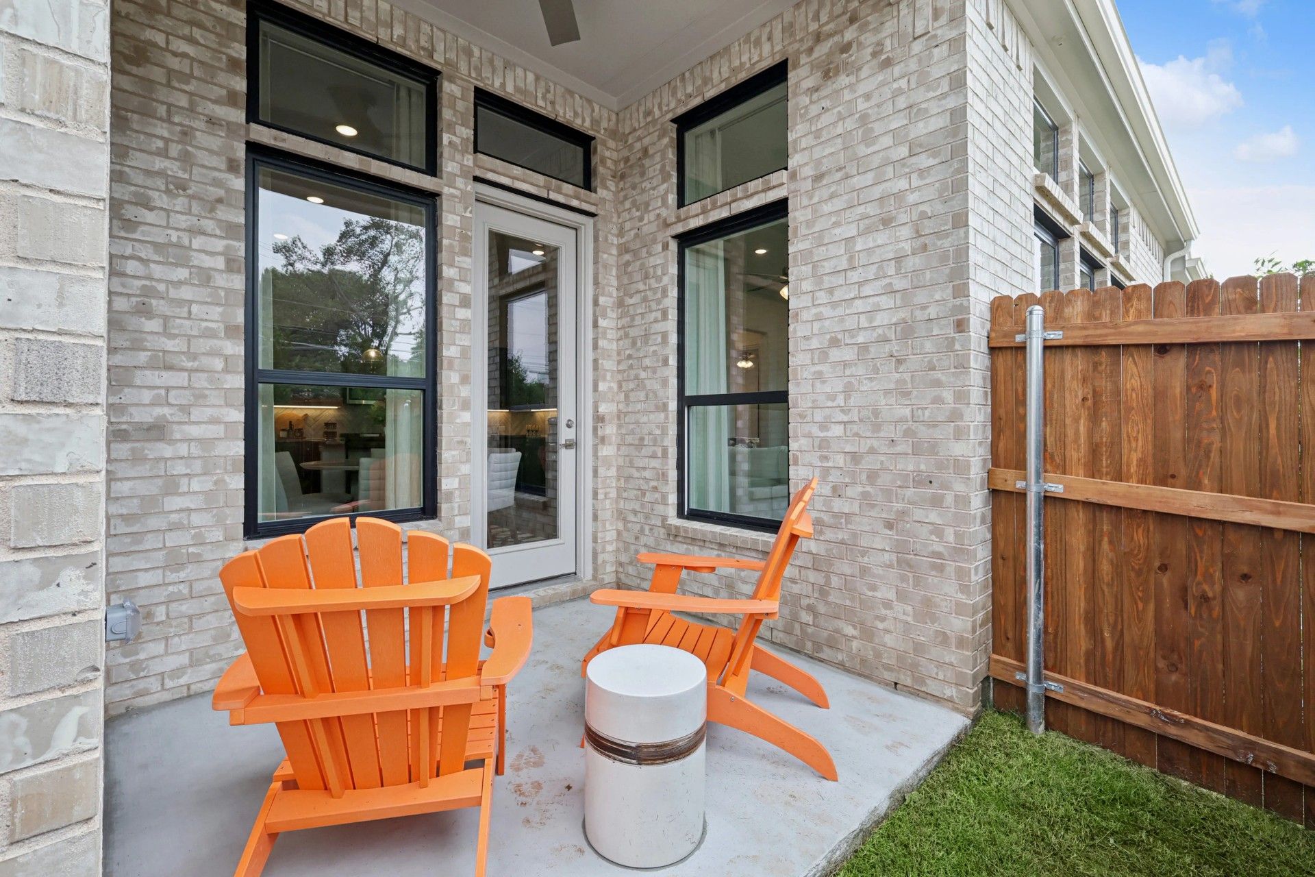 Heritage Park home's patio features elegant beige brick and sleek modern windows.