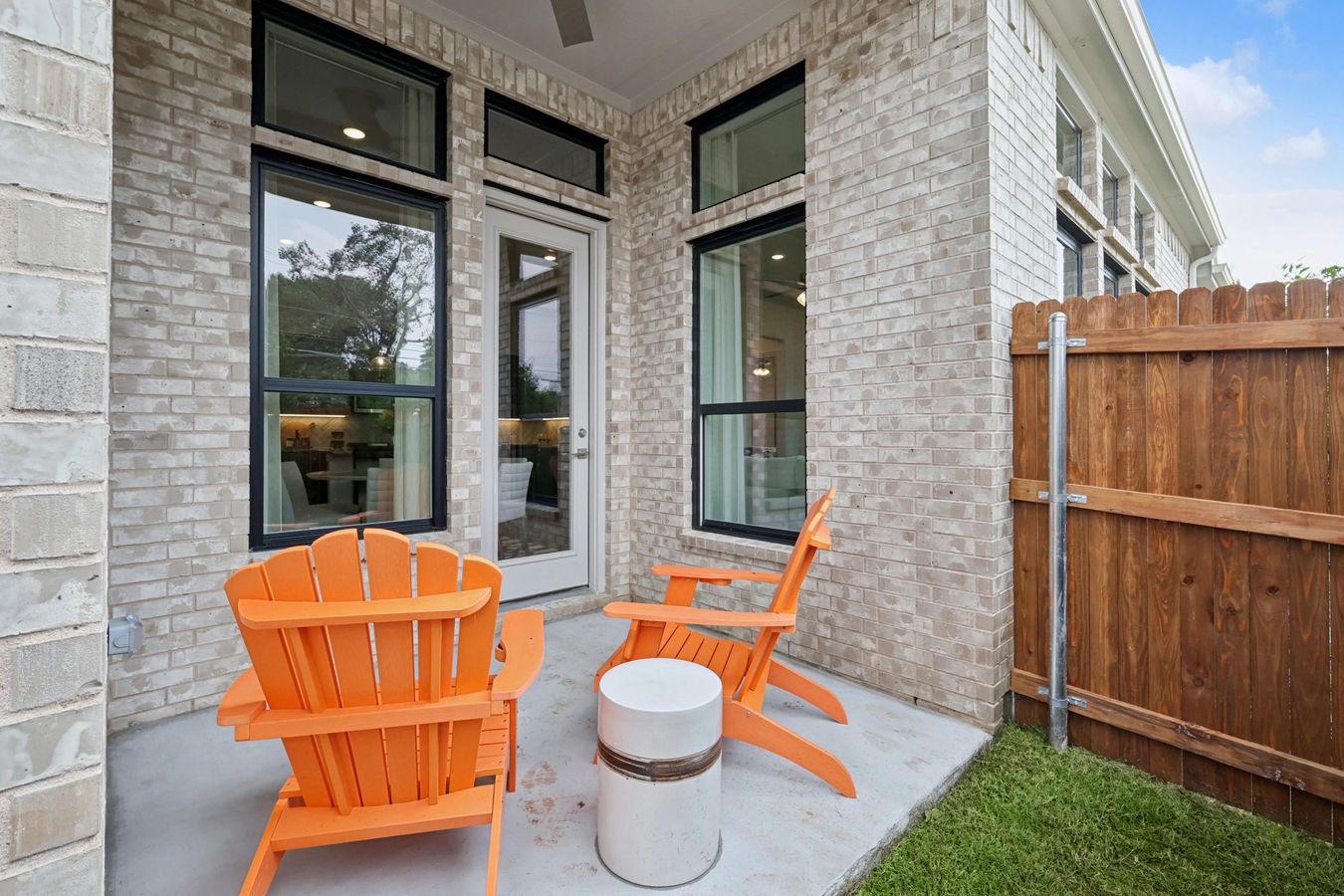 Heritage Park home's patio features elegant beige brick and sleek modern windows.