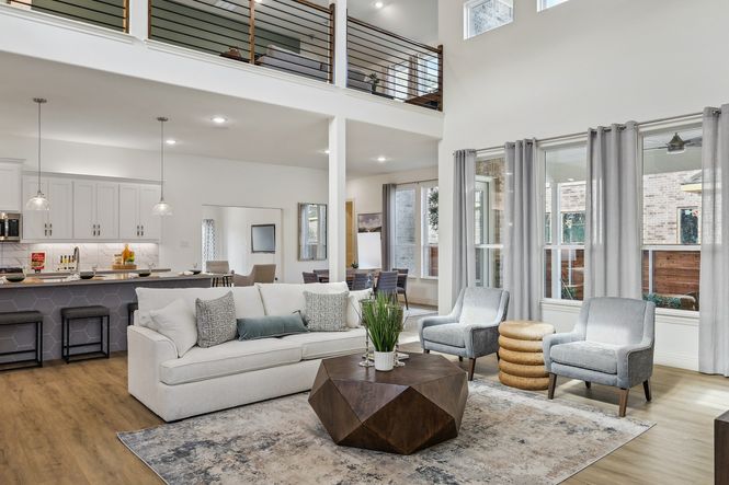 Experience airy elegance in Solterra, Texas. Sleek railing, expansive windows, and premium wood floors elevate style.