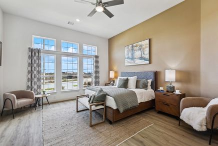 Expansive windows, plush textiles, and sleek hardwood define this discerning Solterra, Texas bedroom.