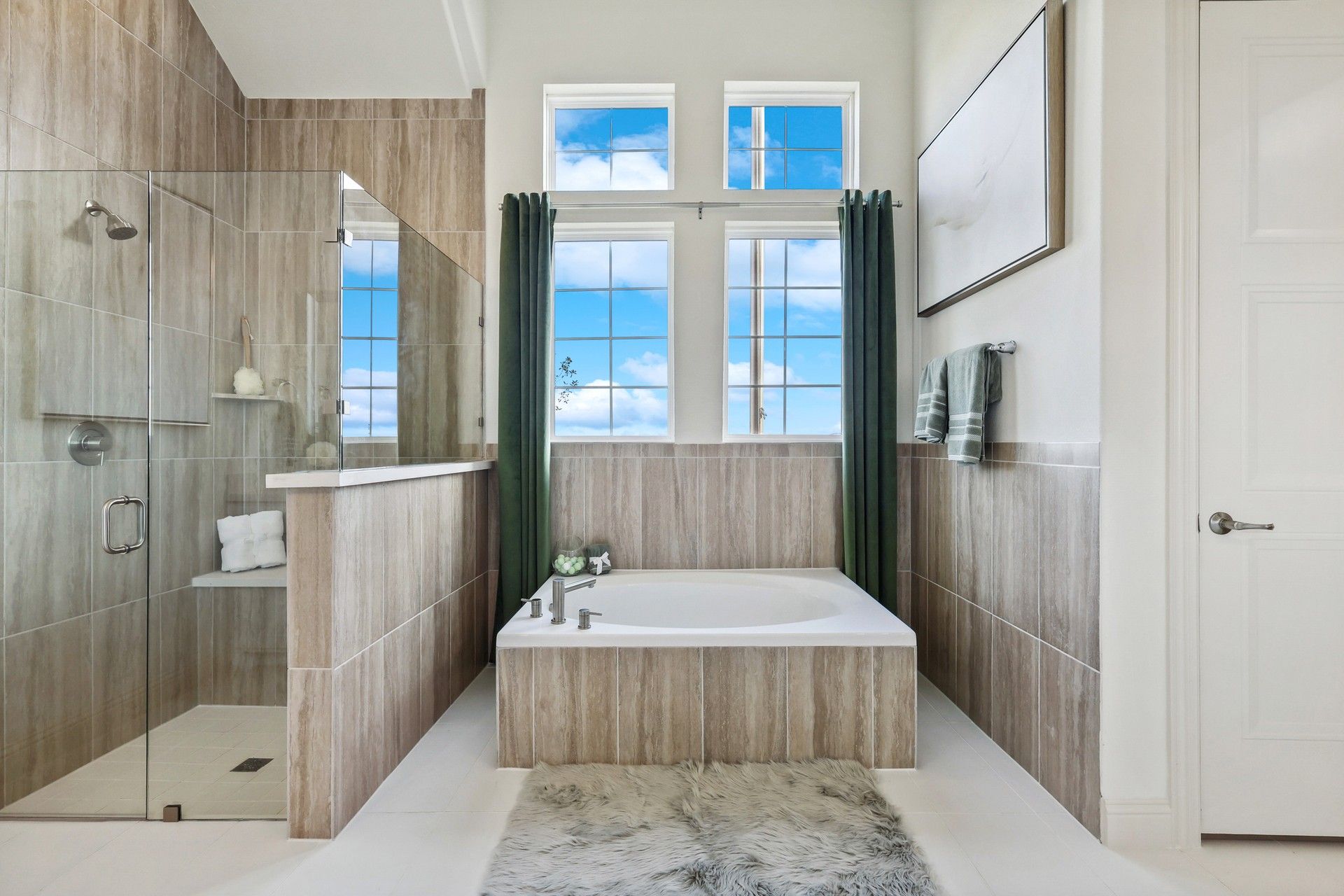 Experience opulence with glass-enclosed shower, jetted tub, and sky-lit windows in Solterra, Texas.