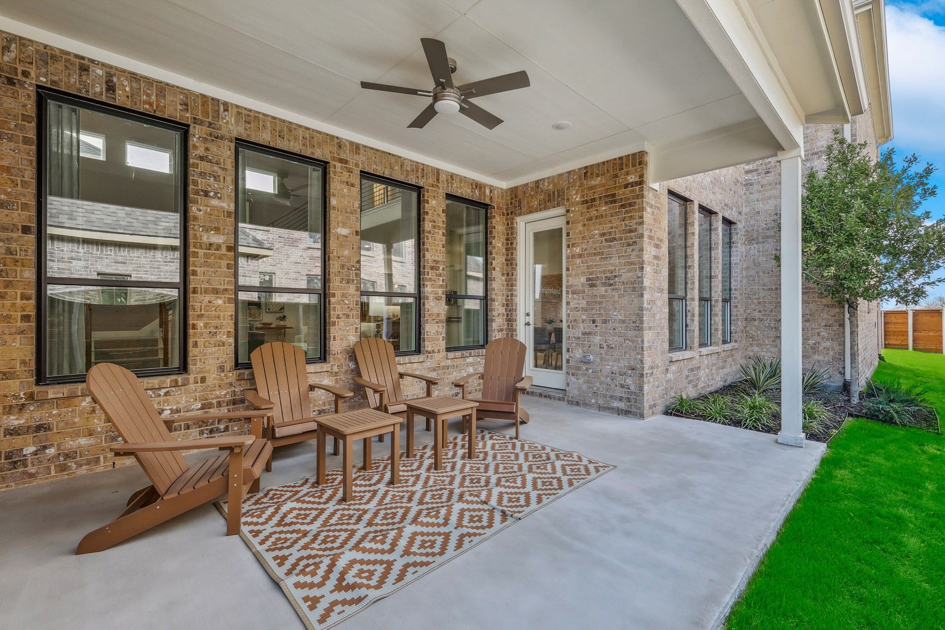 Sophisticated covered patio with brick masonry and sleek ceiling fan in Solterra, Texas.