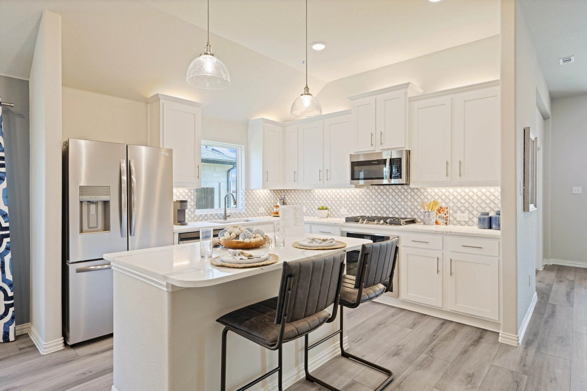Elegant Pebblebrook kitchen boasts sleek white cabinetry and premium stainless steel appliances.