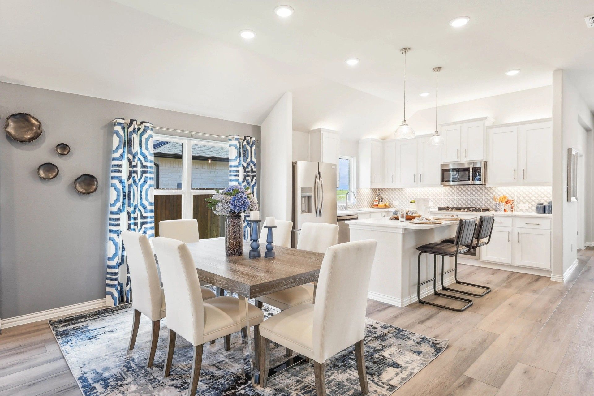 Luxurious kitchen featuring chic white cabinetry and premium wood flooring in Texas home.