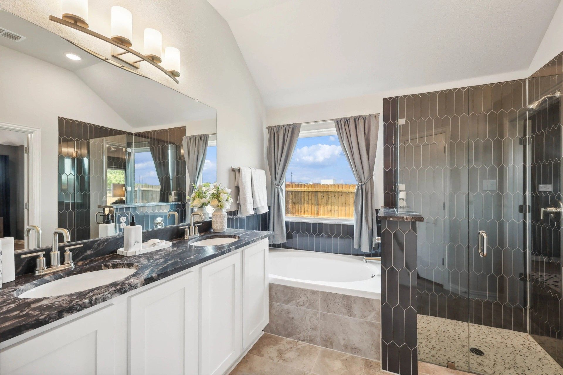 Stunning Pebblebrook bathroom features marble countertops, dual sinks, and a sleek glass shower.