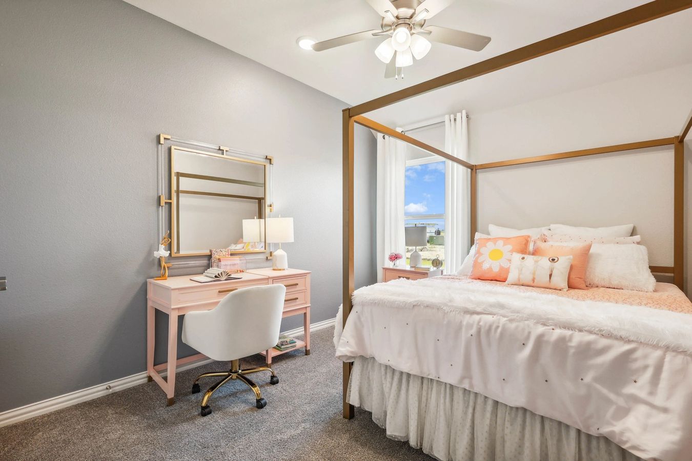 Pebblebrook bedroom features luxurious pink vanity, gold accents, plush bedding, and elegant ceiling fan.