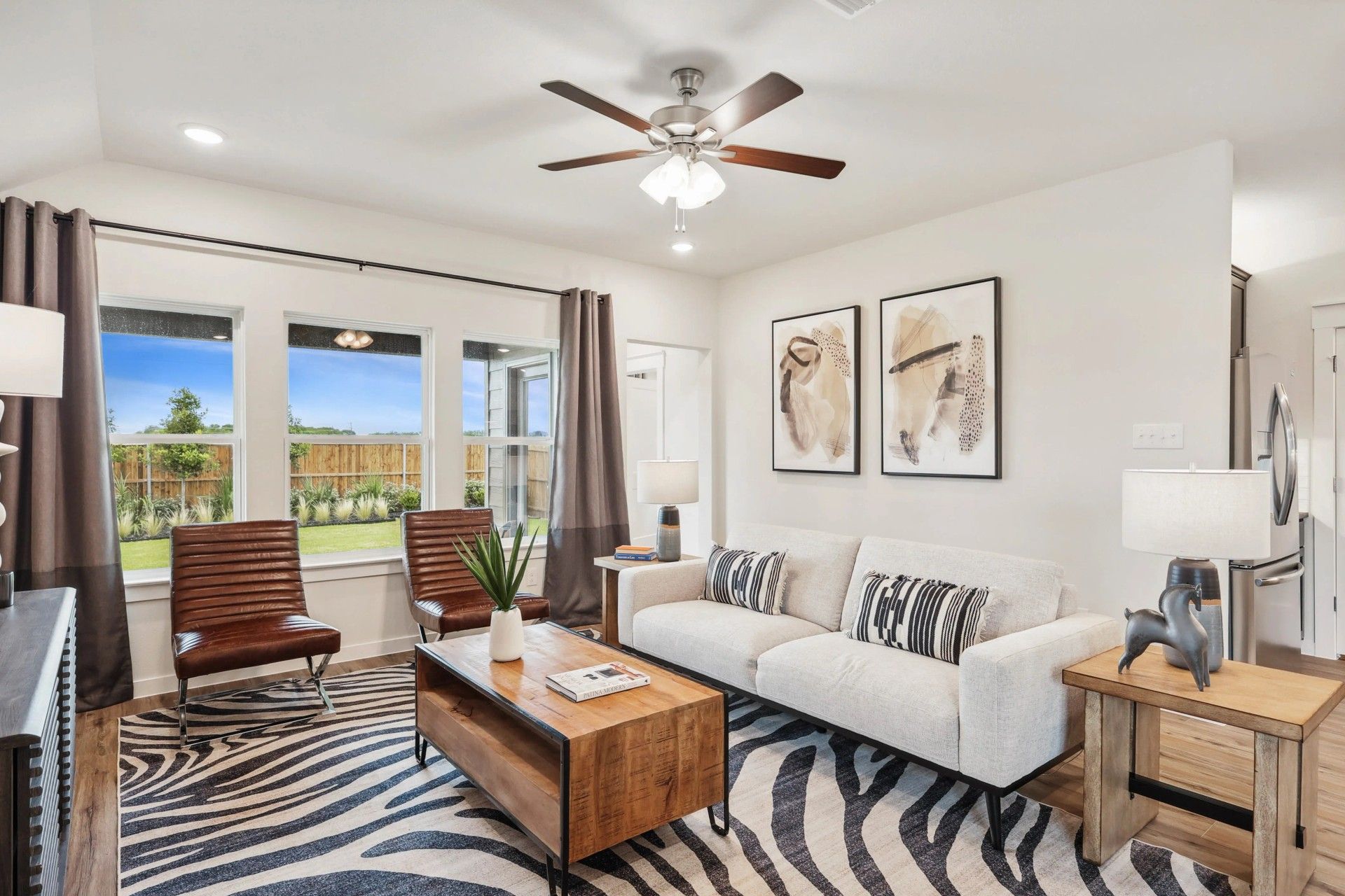 Elegant zebra rug, abstract art, and wood accents enrich this Simpson Crossing living room.
