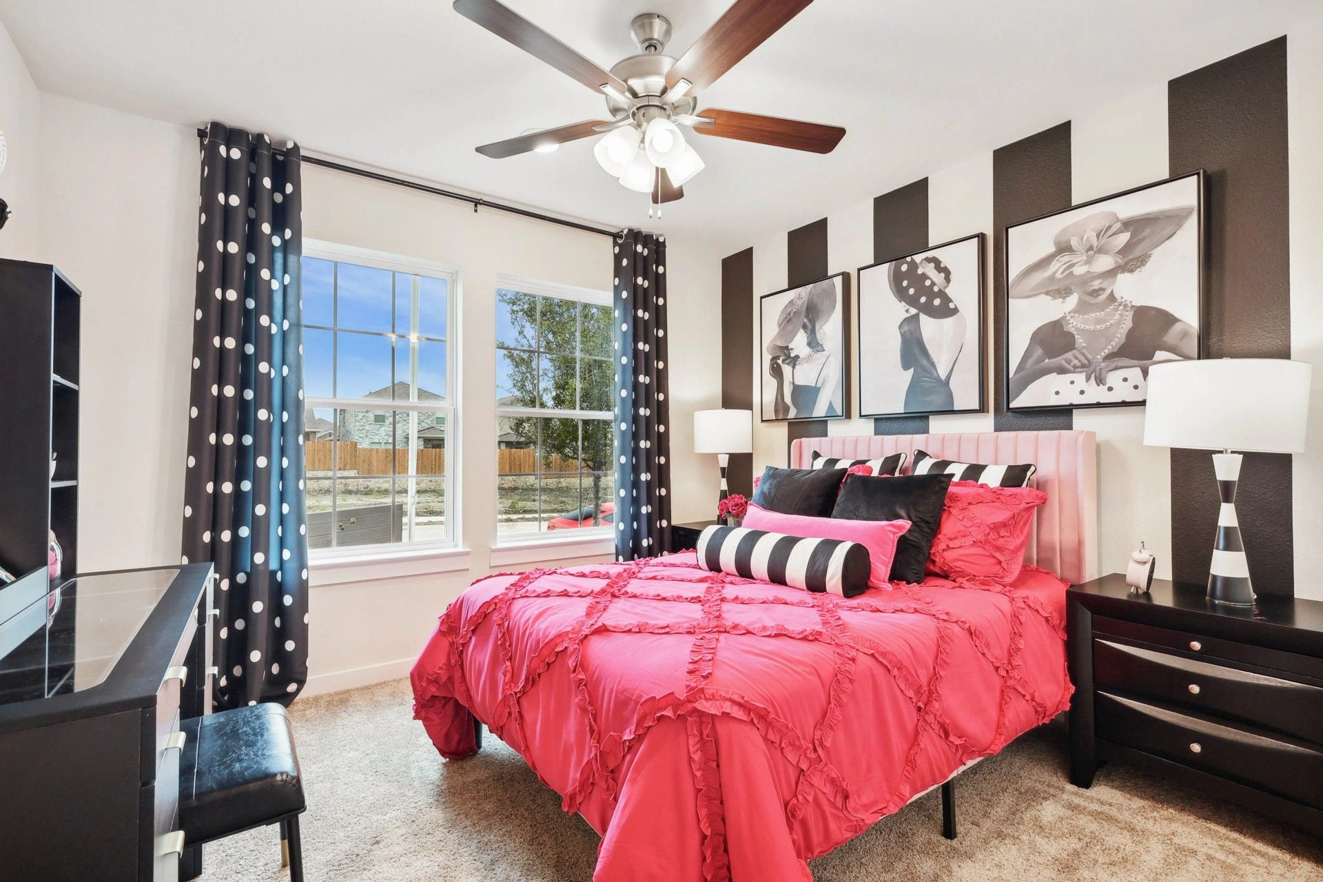 Simpson Crossing's bedroom features chic pink bedding, striped wall art, and elegant polka dot accents.