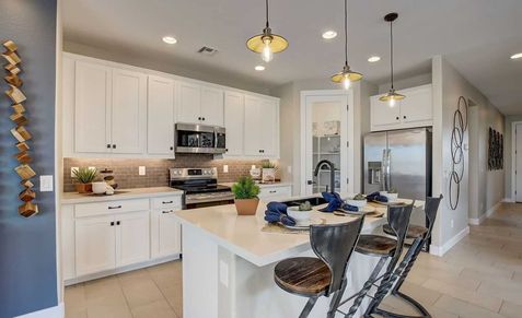 Discover elegant white cabinetry and stylish pendant lighting in Castillo at Anderson Parc. Experience upscale finishes.