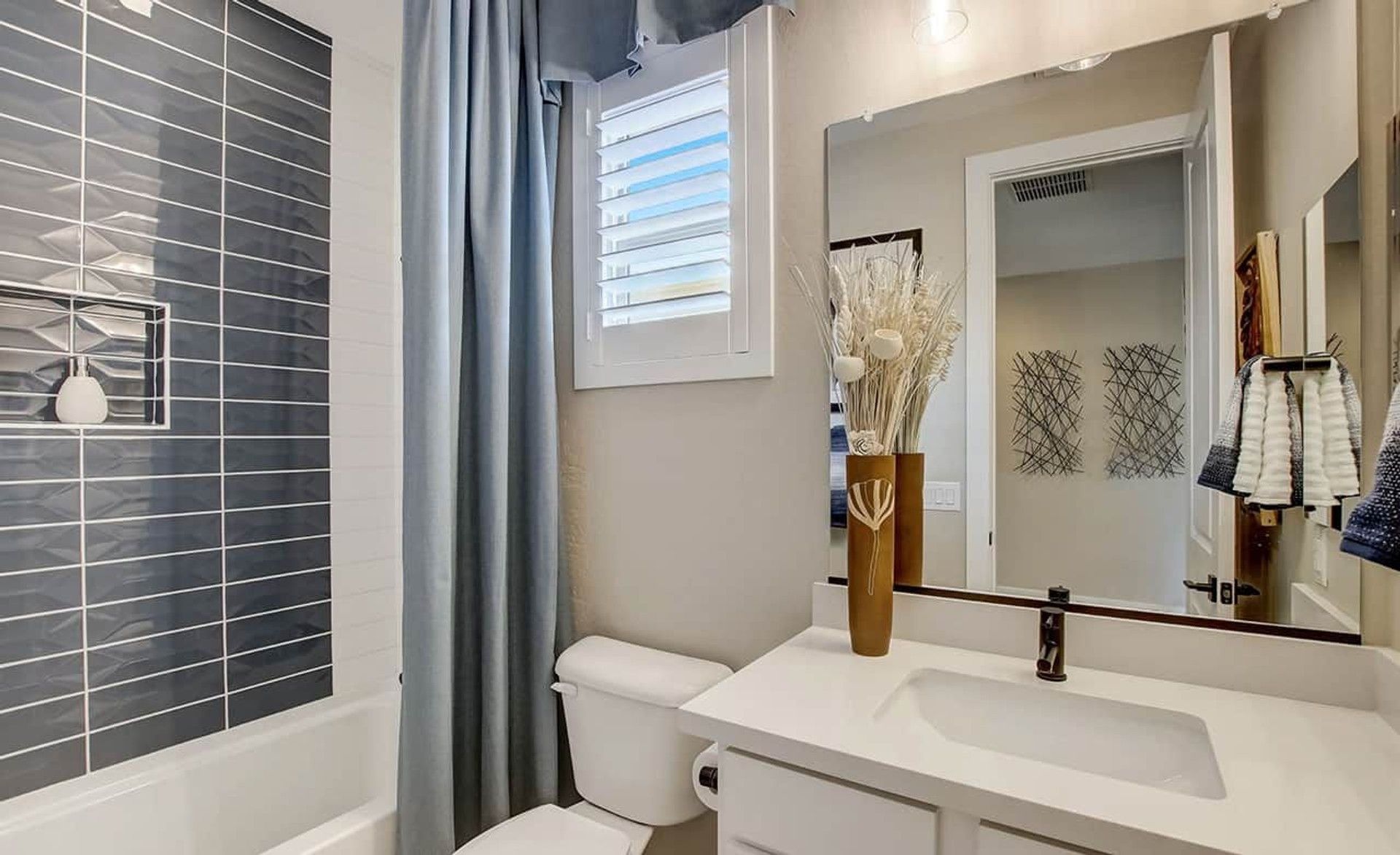 Experience luxury with sleek gray tile, elegant white vanity, and premium fixtures in Castillo, Anderson Parc.