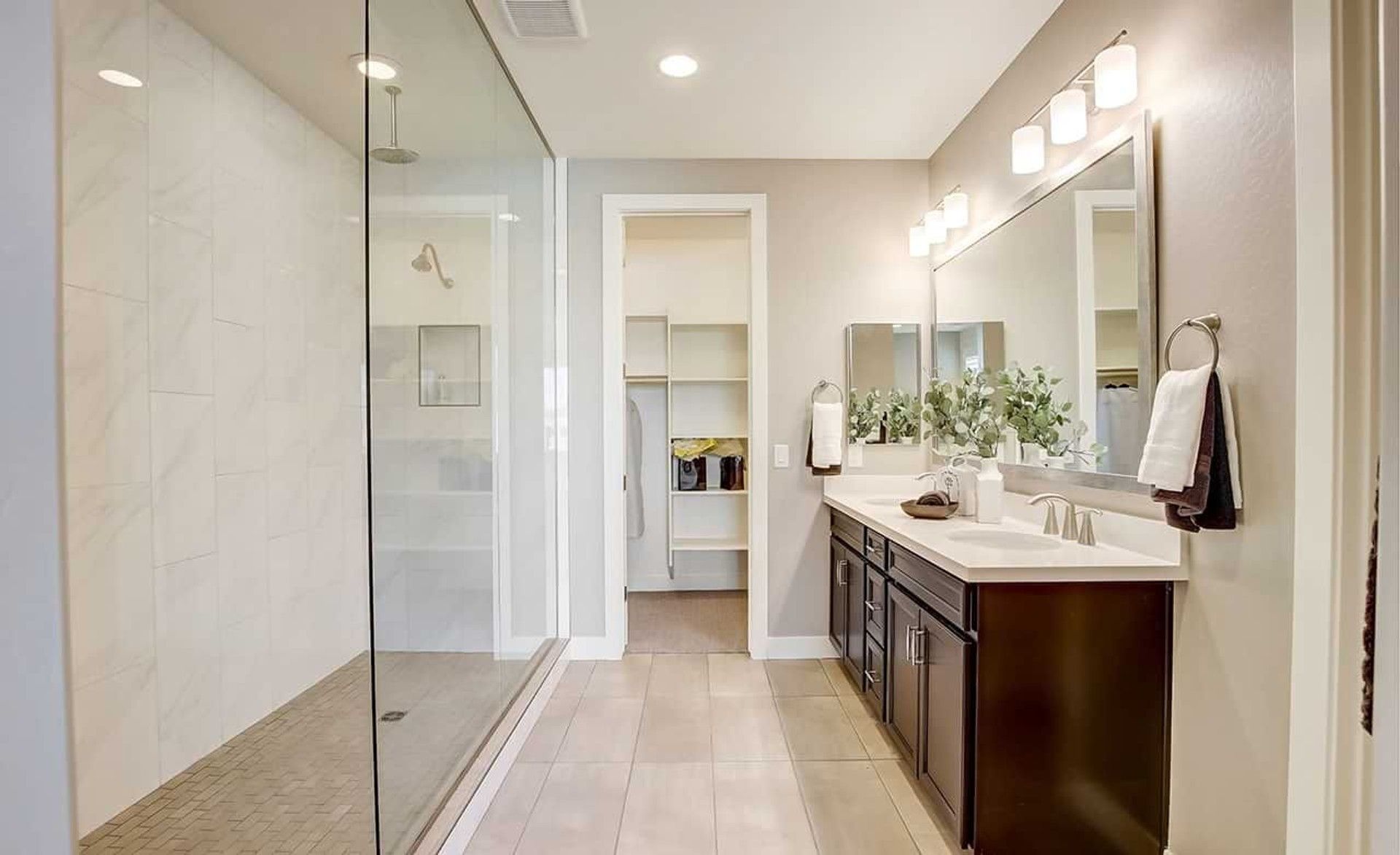 Experience opulence with a vast glass shower, polished double vanity, and exquisite lighting in Anderson Parc.